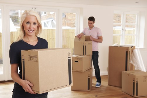 Professional movers carrying household items through a Dagenham property
